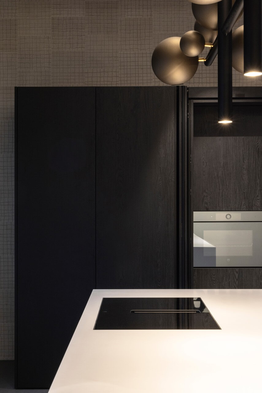 High end designkeuken met wit kookeiland en zwarte kastenwand